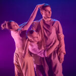 Dancers Madalene Macera, Charlie Wilkins, Bhodi Hudson in pink all in phases of touch.