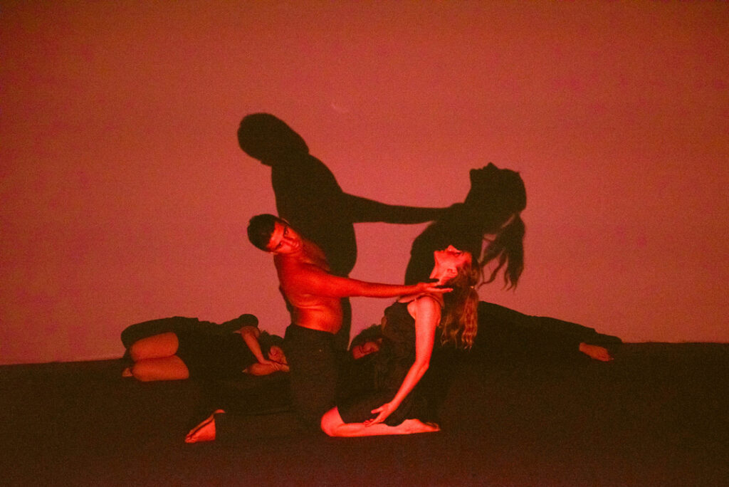 Male and female kneeling on the floor bending away from each other. The male has the back of his hand placed gently on the females shoulder.